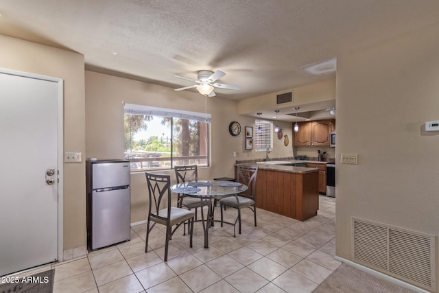 dining area featuring ceiling fan, visible vents, and light tile patterned floors