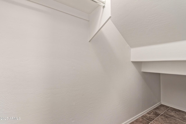 walk in closet featuring dark tile patterned floors