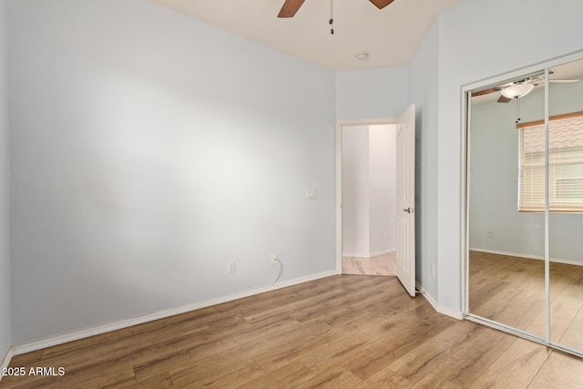 unfurnished bedroom featuring ceiling fan, light hardwood / wood-style floors, and a closet