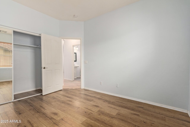 unfurnished bedroom with hardwood / wood-style flooring and a closet