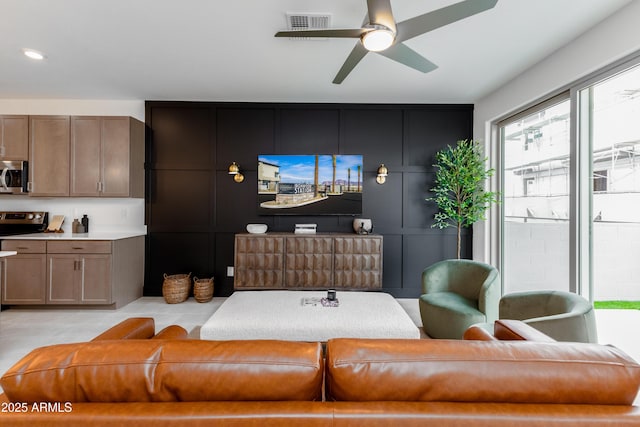 living area featuring a ceiling fan and visible vents