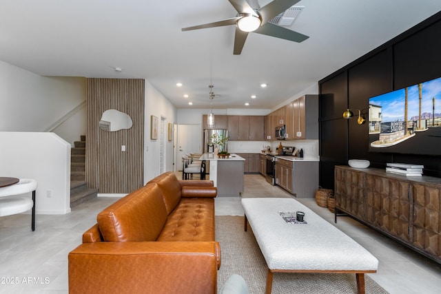 living area featuring light tile patterned floors, a ceiling fan, visible vents, stairway, and recessed lighting
