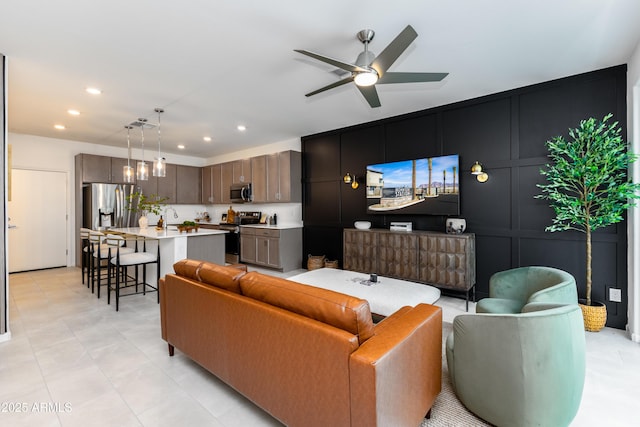 living area with a decorative wall, ceiling fan, and recessed lighting