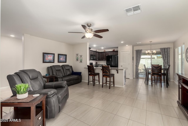 living room featuring ceiling fan with notable chandelier