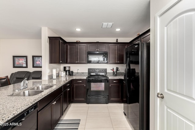 kitchen featuring dark brown cabinetry, sink, light tile patterned floors, and black appliances