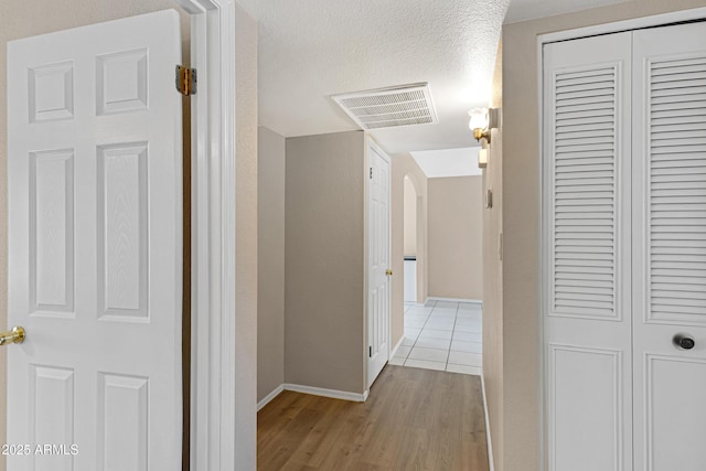 corridor with wood finished floors and baseboards