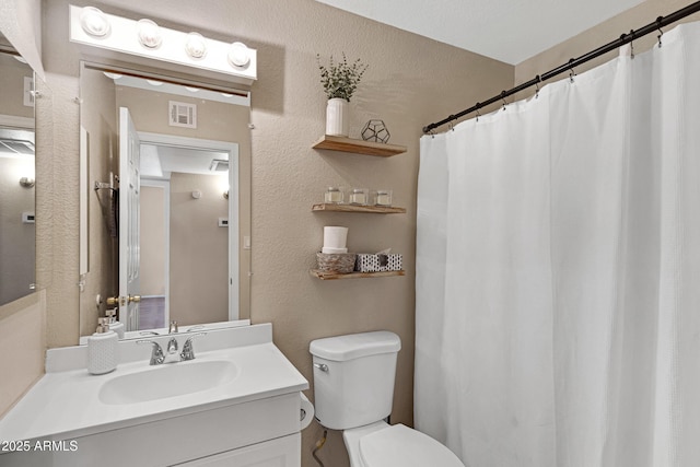 full bath with toilet, vanity, a textured wall, and a shower with shower curtain
