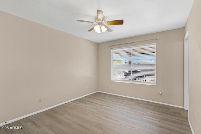 spare room with wood finished floors, baseboards, and ceiling fan