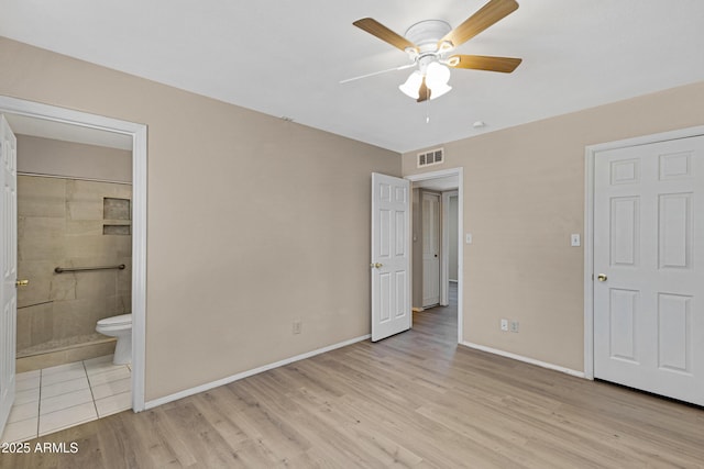 unfurnished bedroom featuring light wood-type flooring, baseboards, connected bathroom, and a ceiling fan