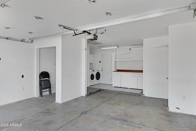 garage with washer and clothes dryer and a garage door opener