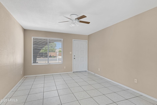 unfurnished room with a ceiling fan and baseboards