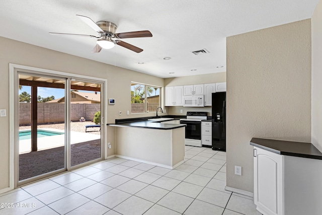 kitchen featuring range with electric stovetop, white microwave, black refrigerator with ice dispenser, a peninsula, and dark countertops