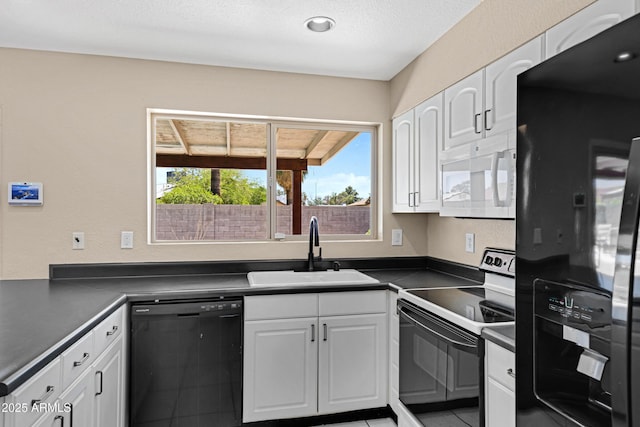 kitchen featuring black appliances, a sink, dark countertops, white cabinetry, and light tile patterned flooring