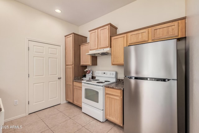 kitchen featuring light brown cabinetry, dark stone countertops, stainless steel fridge, light tile patterned floors, and white range with electric cooktop