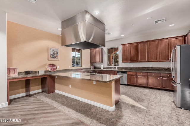 kitchen with light tile patterned flooring, island range hood, dark stone counters, kitchen peninsula, and stainless steel appliances