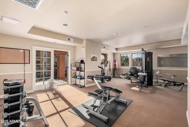 workout room with a raised ceiling, carpet, and french doors