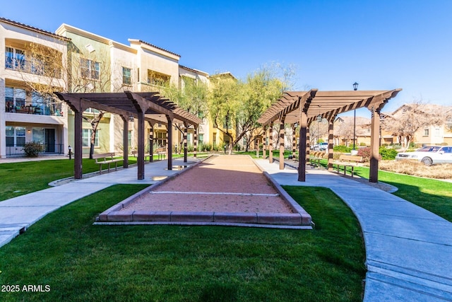 view of property's community with a pergola and a lawn