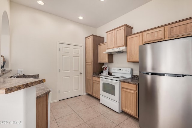 kitchen with white range with electric stovetop, light tile patterned flooring, light brown cabinetry, and stainless steel refrigerator