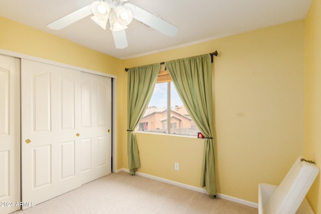 unfurnished bedroom with light colored carpet, ceiling fan, and a closet