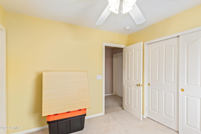 bedroom with light carpet, ceiling fan, and a closet