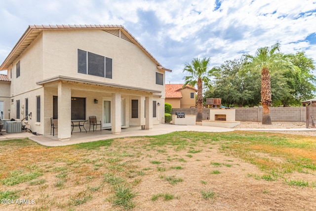 rear view of property featuring exterior kitchen, a patio area, and central air condition unit