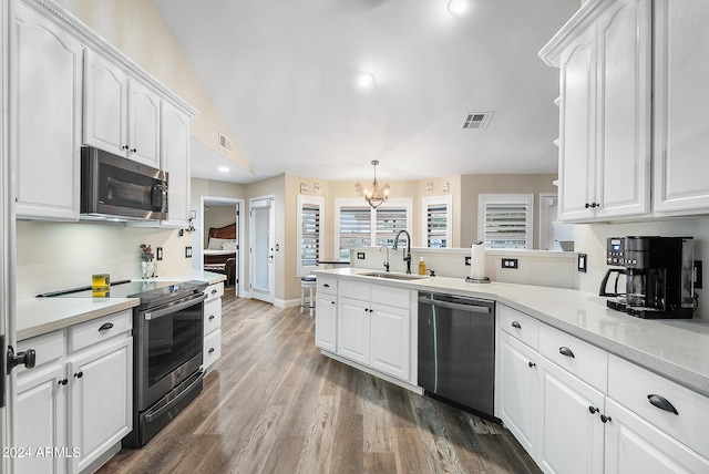 kitchen featuring hanging light fixtures, white cabinetry, sink, and stainless steel appliances