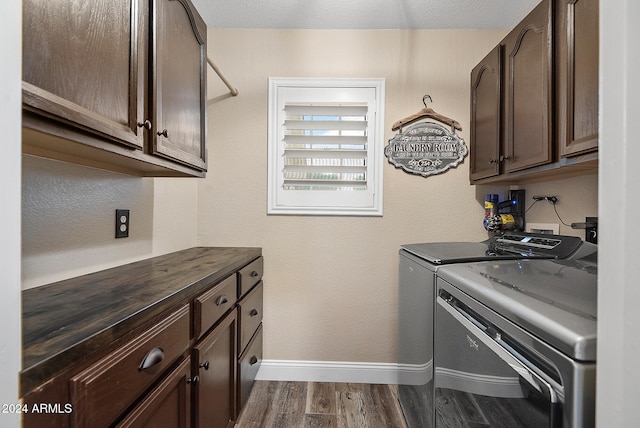 laundry room with washer and dryer, dark hardwood / wood-style floors, and cabinets