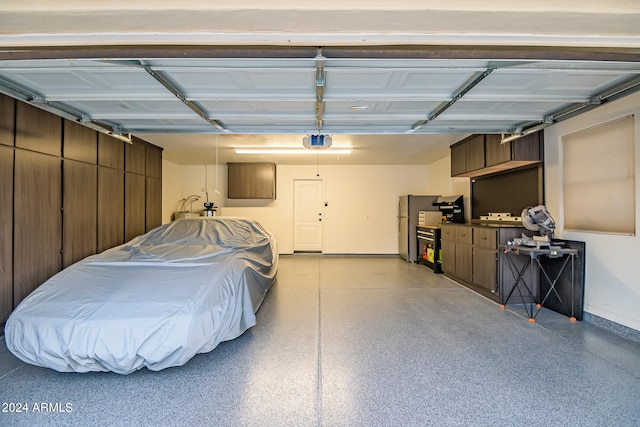 garage featuring a garage door opener and stainless steel refrigerator