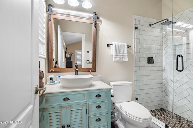 bathroom with vanity, toilet, and a shower with door