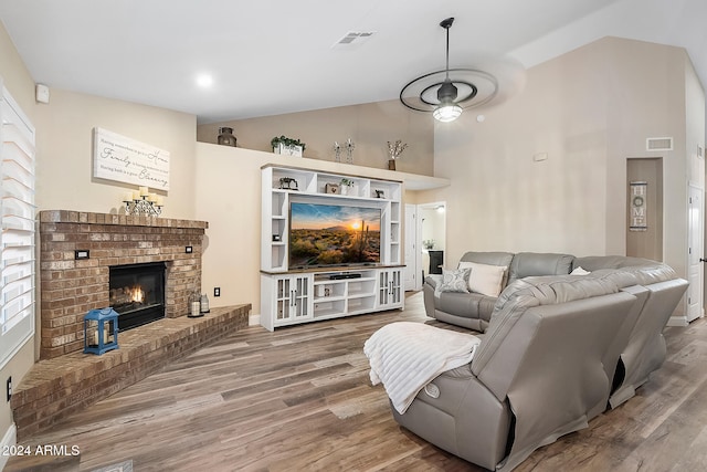 living room with a fireplace, wood-type flooring, and lofted ceiling