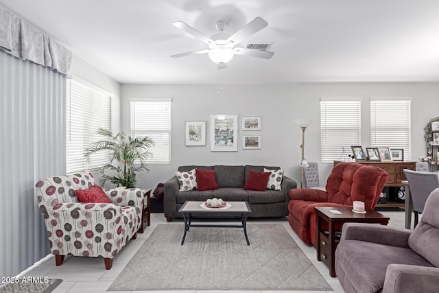 living area featuring light tile patterned floors and ceiling fan
