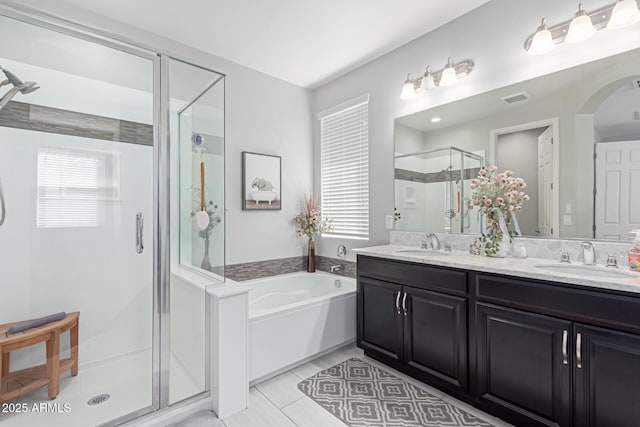bathroom with a garden tub, visible vents, a stall shower, and a sink