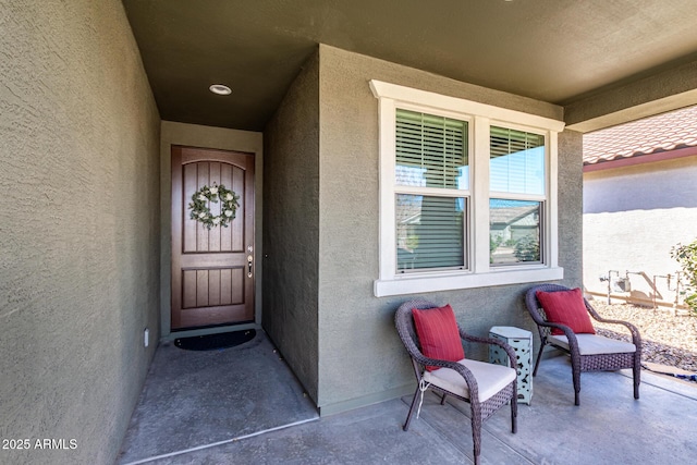 doorway to property featuring stucco siding and a tiled roof