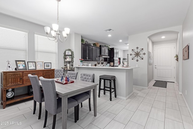 dining space with visible vents, baseboards, recessed lighting, an inviting chandelier, and arched walkways