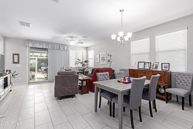 dining space with ceiling fan with notable chandelier and visible vents