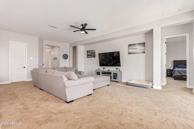 carpeted living room with ceiling fan