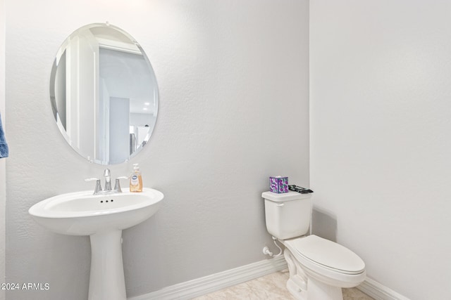 bathroom with toilet and tile patterned flooring