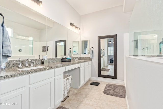 bathroom featuring dual vanity, tile patterned floors, and a towering ceiling