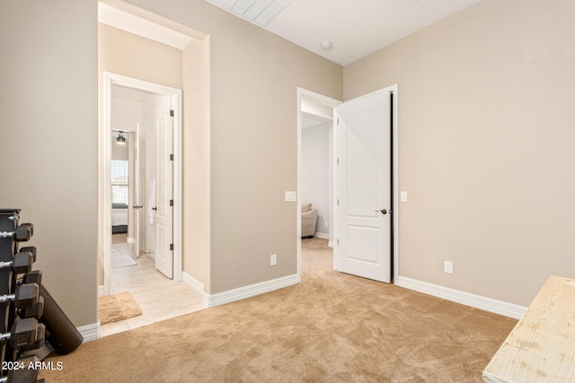 bedroom with connected bathroom and light colored carpet