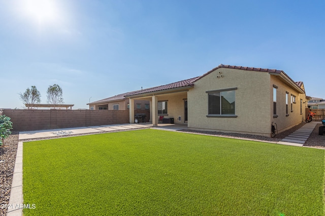 rear view of house with a patio and a yard