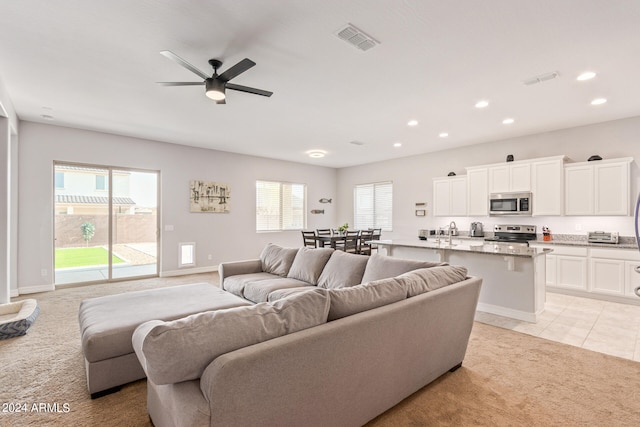 tiled living room featuring sink and ceiling fan