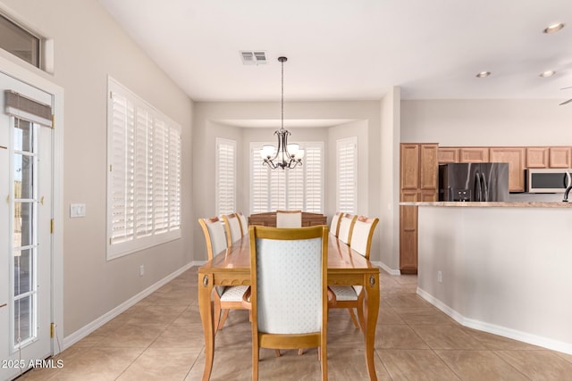 dining space featuring light tile patterned floors and a chandelier