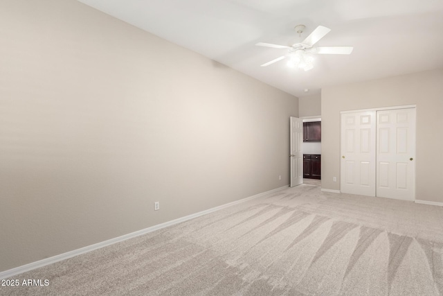 unfurnished bedroom featuring ceiling fan, light carpet, and a closet