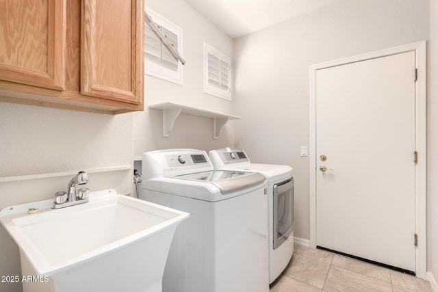 laundry area featuring light tile patterned flooring, cabinets, sink, and washing machine and clothes dryer