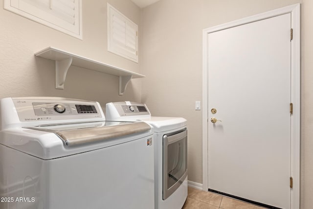 clothes washing area with separate washer and dryer and light tile patterned floors