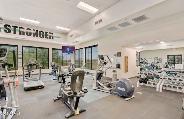 gym featuring a towering ceiling and a paneled ceiling