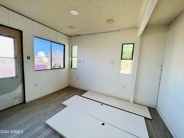 spare room featuring a textured ceiling and hardwood / wood-style flooring