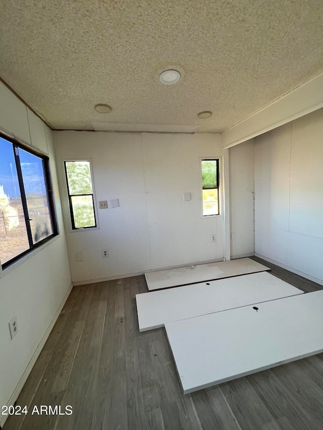 spare room featuring a textured ceiling and dark wood-type flooring