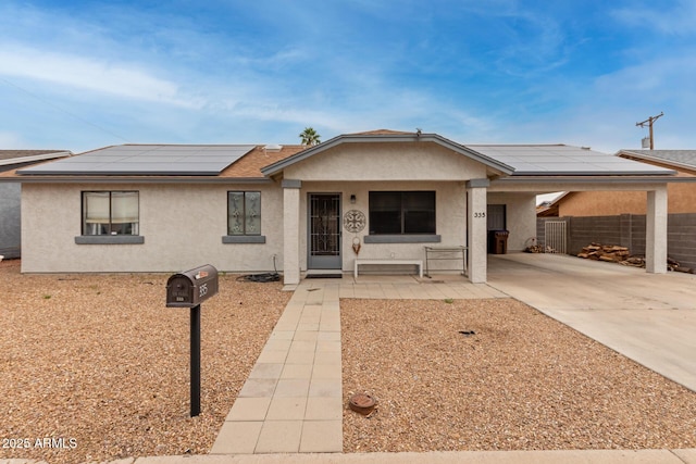 ranch-style home featuring a carport and solar panels