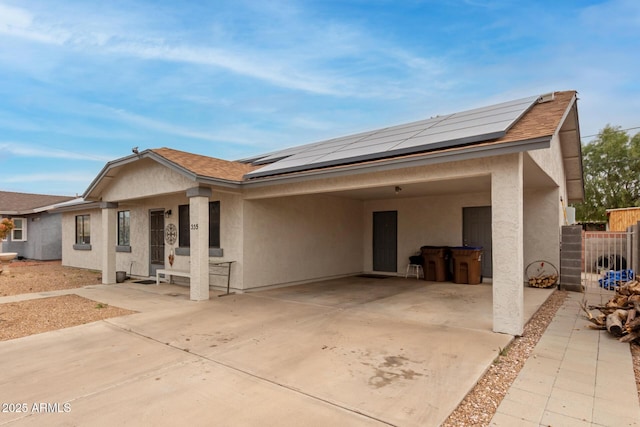 view of front of house with solar panels and a patio area